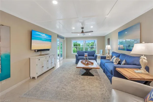 a living room with furniture a flat screen tv and a large window