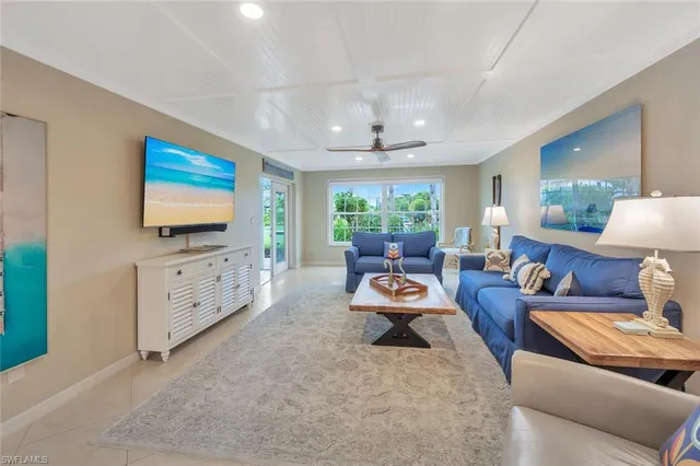 a living room with furniture a flat screen tv and a large window