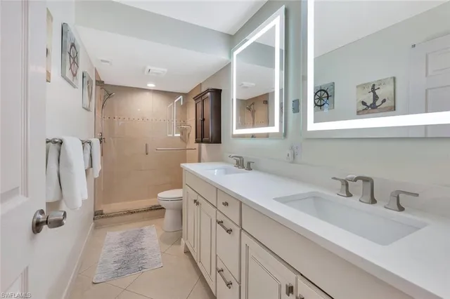 a bathroom with a double vanity sink mirror and toilet