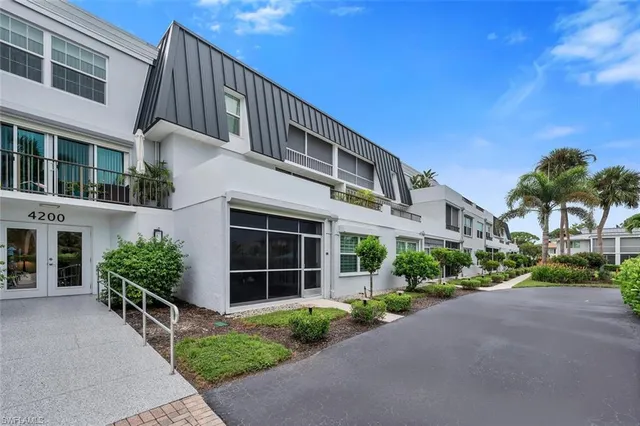 a front view of a house with a yard and potted plants
