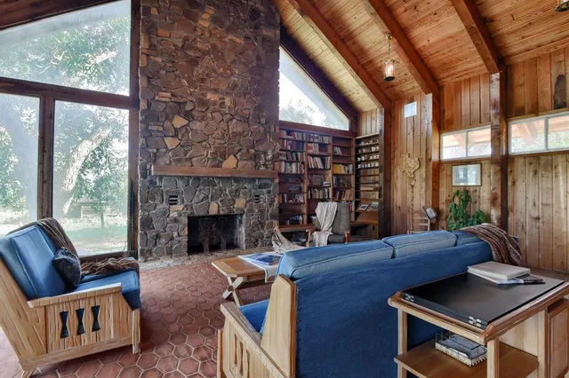 a living room with furniture fireplace and a large window