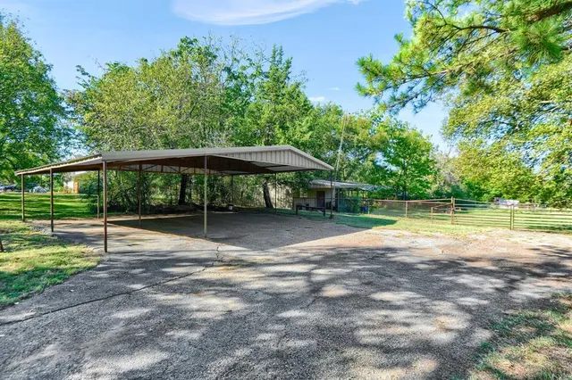 a view of a house with a backyard and a large tree