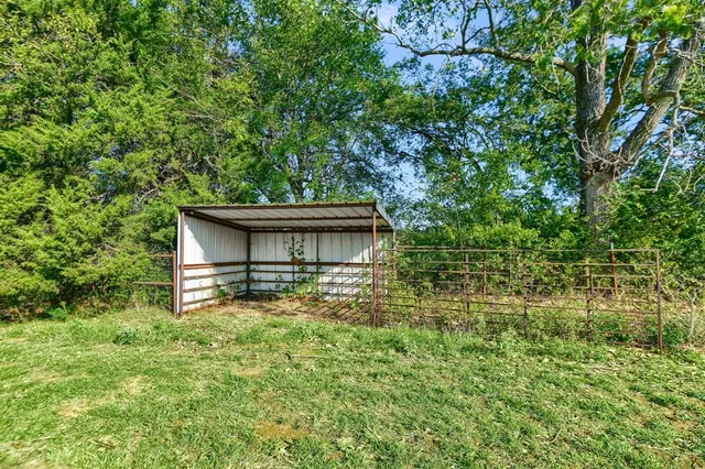 a view of a yard with wooden fence