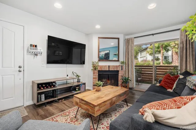 a living room with furniture a flat screen tv and a fireplace