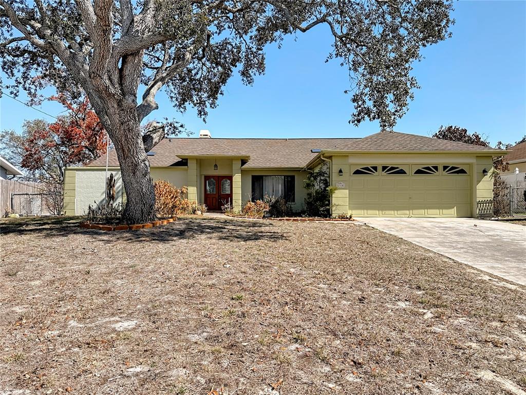 5066 Woodbine Street Spring Hill, FL 34608 - Photo 1 of 59 a front view of a house with garden
