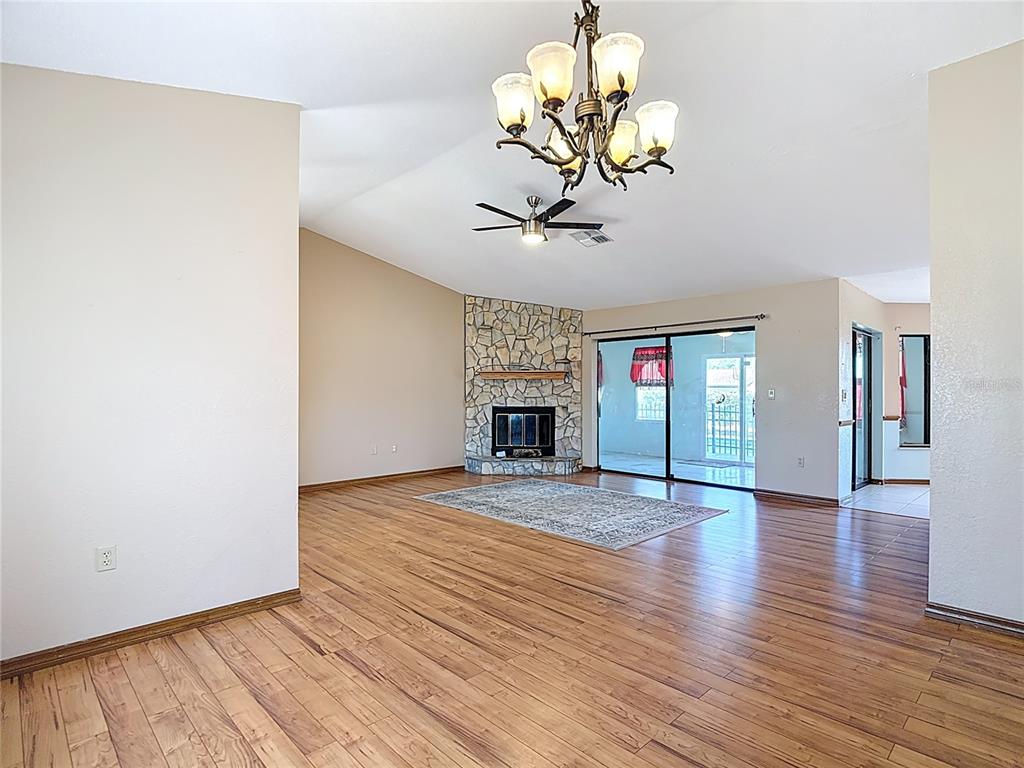 5066 Woodbine Street Spring Hill, FL 34608 - Photo 12 of 59 a view of an empty room with a window and wooden floor