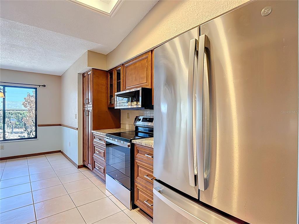 5066 Woodbine Street Spring Hill, FL 34608 - Photo 14 of 59 a kitchen with stainless steel appliances a refrigerator sink and microwave