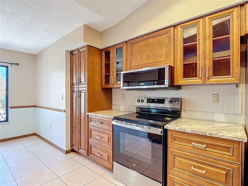 5066 Woodbine Street Spring Hill, FL 34608 - Photo 15 of 59 a kitchen with stainless steel appliances granite countertop a stove and a microwave
