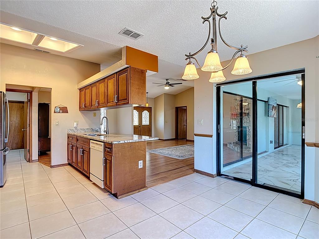 5066 Woodbine Street Spring Hill, FL 34608 - Photo 20 of 59 a kitchen with stainless steel appliances granite countertop a stove a refrigerator and a sink