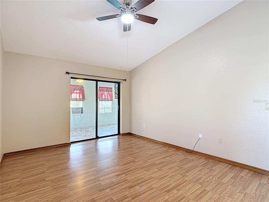 5066 Woodbine Street Spring Hill, FL 34608 - Photo 33 of 59 a view of an empty room with wooden floor and a ceiling fan