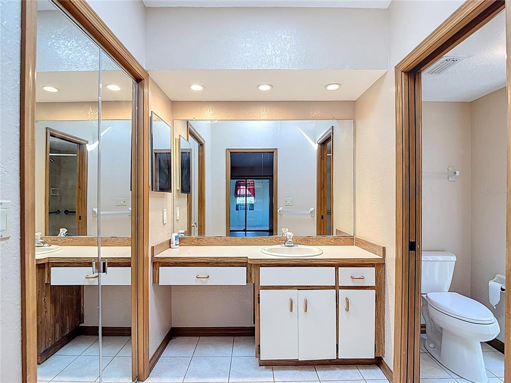 5066 Woodbine Street Spring Hill, FL 34608 - Photo 35 of 59 a bathroom with a sink a toilet and a large mirror