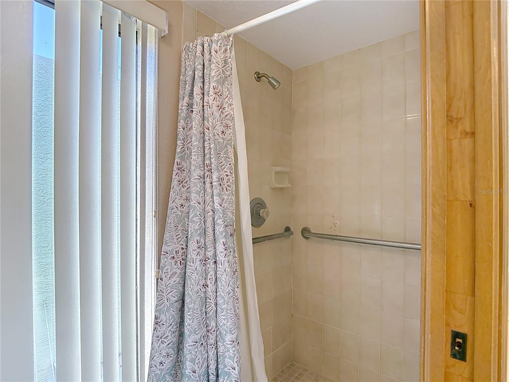 5066 Woodbine Street Spring Hill, FL 34608 - Photo 37 of 59 a bathroom with a shower curtain and a window