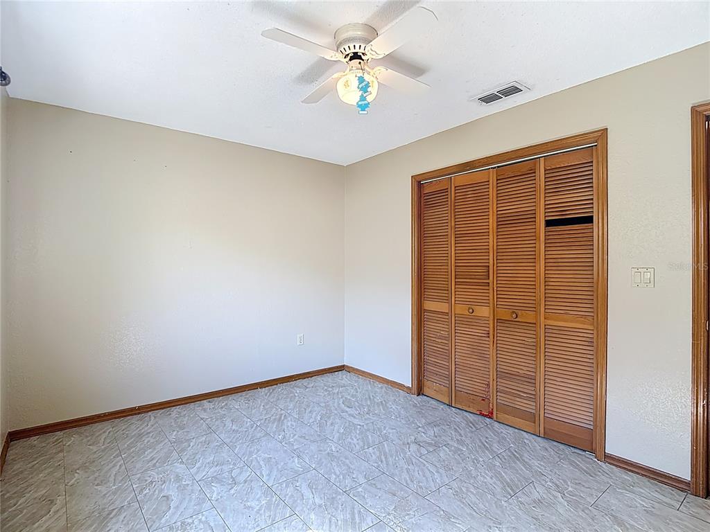 5066 Woodbine Street Spring Hill, FL 34608 - Photo 43 of 59 an empty room with closet and fan