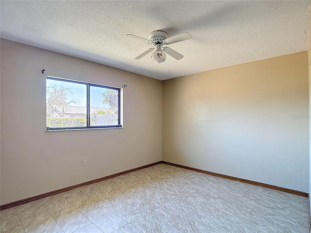 5066 Woodbine Street Spring Hill, FL 34608 - Photo 46 of 59 an empty room with a ceiling fan and window