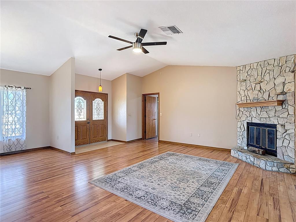 5066 Woodbine Street Spring Hill, FL 34608 - Photo 8 of 59 a view of a livingroom with wooden floor and a fireplace