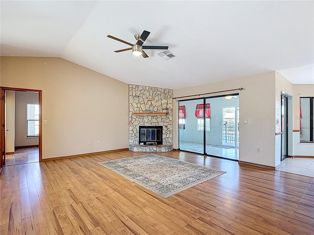 5066 Woodbine Street Spring Hill, FL 34608 - Photo 9 of 59 a view of a livingroom with wooden floor and a fireplace