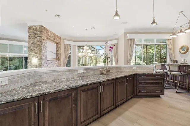 a bathroom with a granite countertop sink a mirror and next to a window