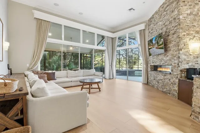 a spacious bedroom with a bed a dresser and a chandelier