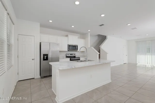 a large kitchen with stainless steel appliances granite countertop a stove and a sink