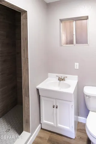 a bathroom with a sink a toilet and shower