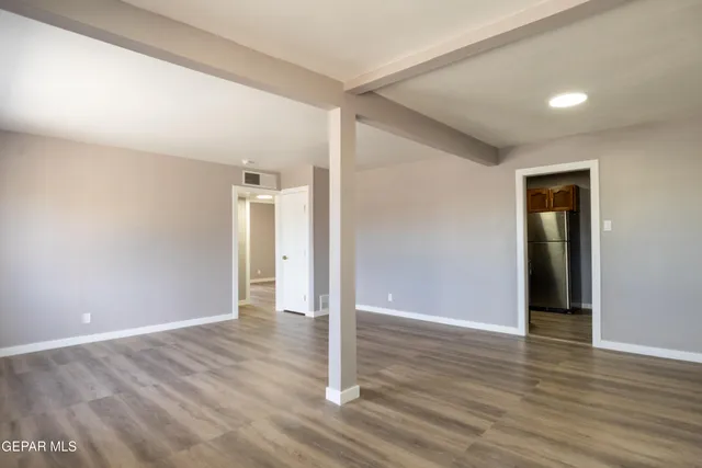 a view of an empty room with wooden floor