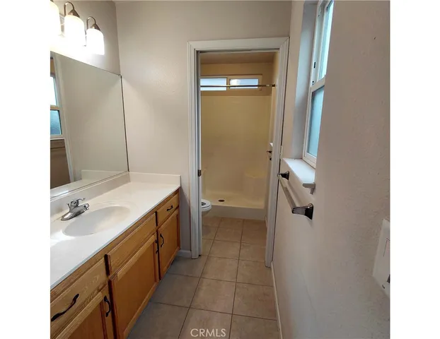 a spacious bathroom with a double vanity sink a mirror and a shower