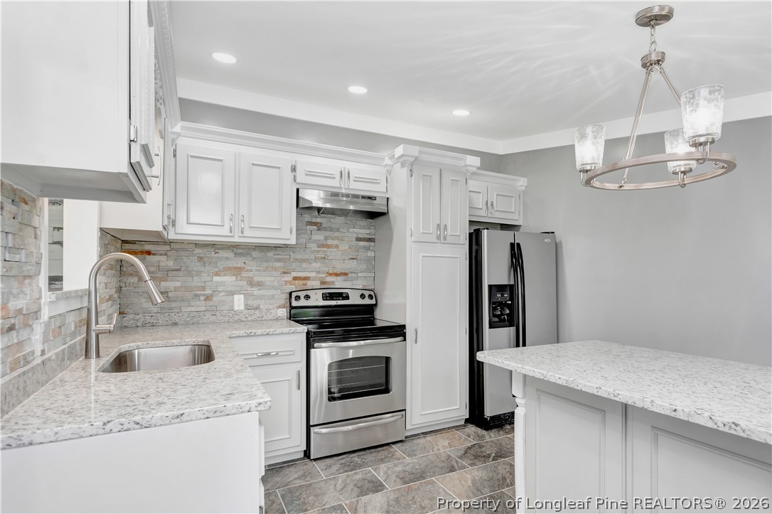 7225 Deep Branch Road Pembroke, NC 28372 - Photo 10 of 27 a kitchen with stainless steel appliances granite countertop a sink stove and refrigerator