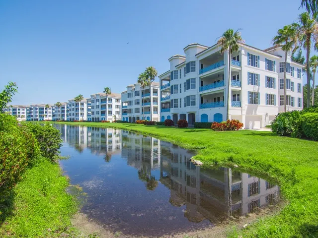 a view of a lake with a building and a yard in front of it