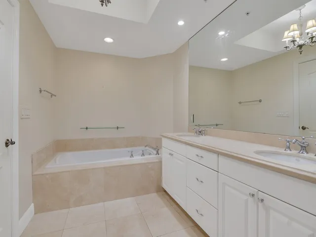 a bathroom with a tub a sink and mirror