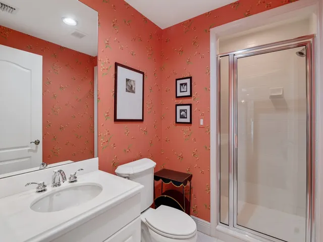 a bathroom with a sink mirror vanity and toilet
