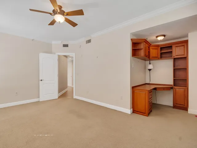 an empty room with closet and fan
