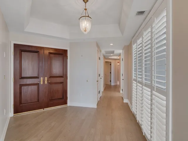 a view of a hallway with wooden floor and closet