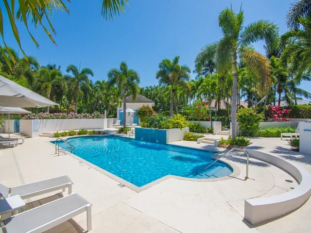 a view of a swimming pool with lounge chairs in patio