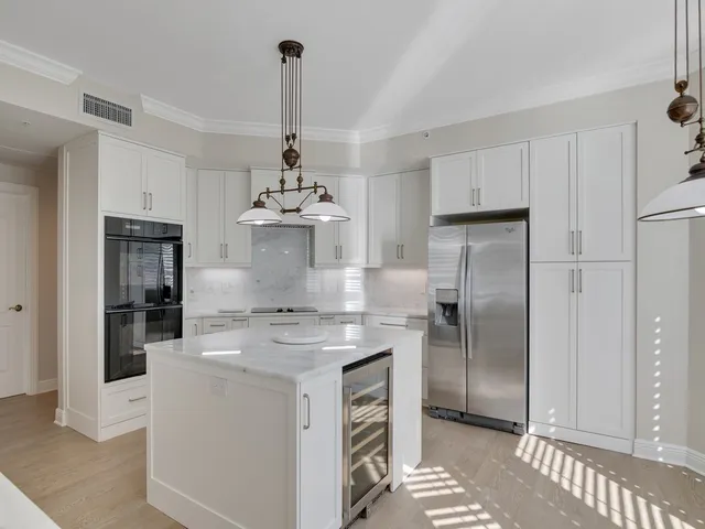 a kitchen with stainless steel appliances granite countertop a sink a refrigerator and a stove