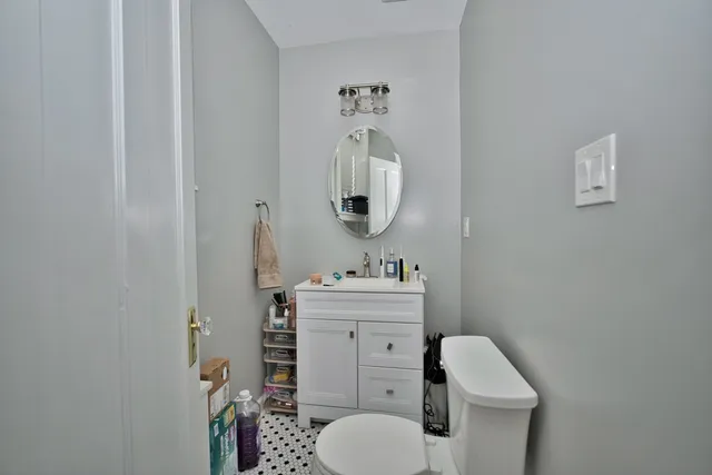 a bathroom with a toilet sink and mirror