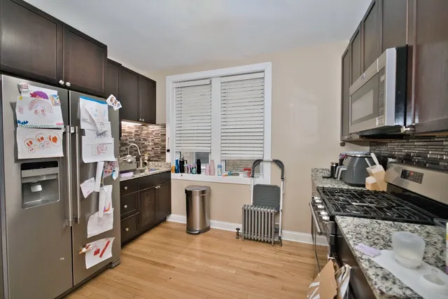 a kitchen with stainless steel appliances granite countertop a stove refrigerator sink and cabinets