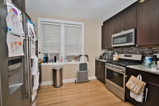 a kitchen with stainless steel appliances granite countertop a stove a sink dishwasher and a microwave oven with cabinets