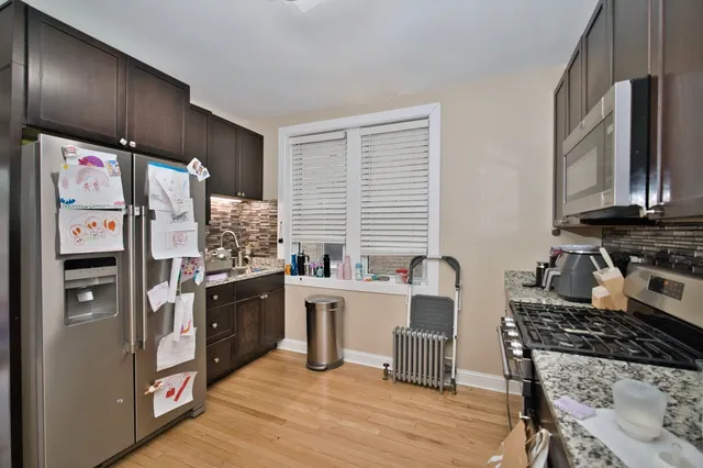 a kitchen with stainless steel appliances granite countertop a stove refrigerator sink and cabinets