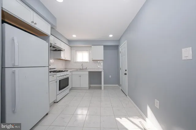 a kitchen with a stove a sink and a refrigerator