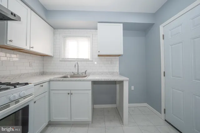 a kitchen with cabinets appliances a sink and a window