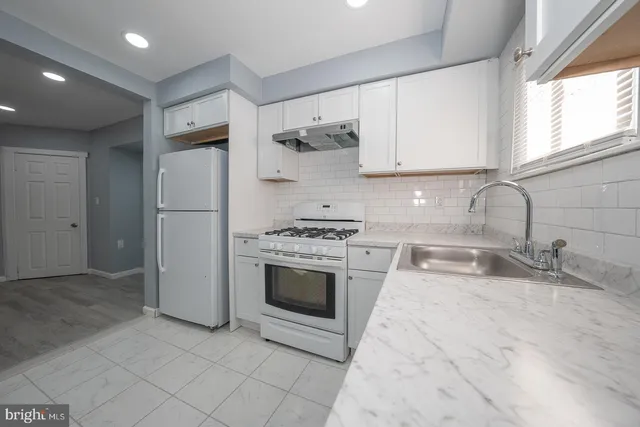 a kitchen with stainless steel appliances granite countertop a sink and a stove