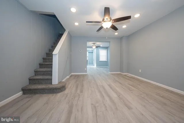 wooden floor in an empty room with a chandelier