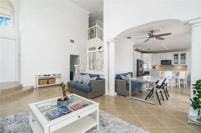 a living room with furniture a table and kitchen view