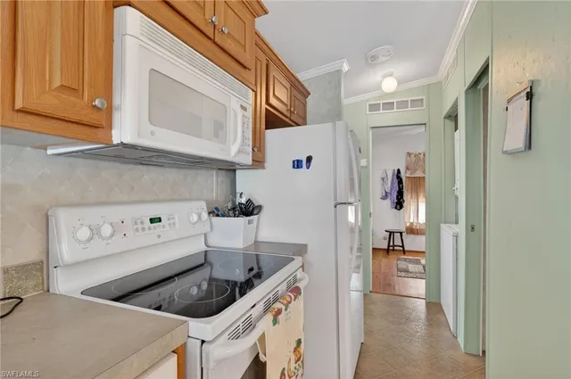 a kitchen with stainless steel appliances granite countertop a table chairs in it and wooden floors