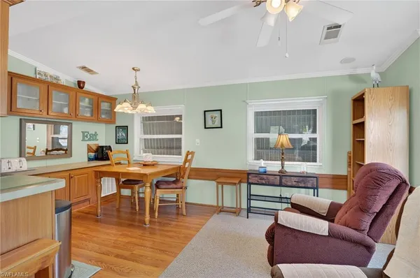 a living room with furniture a chandelier and a dining table