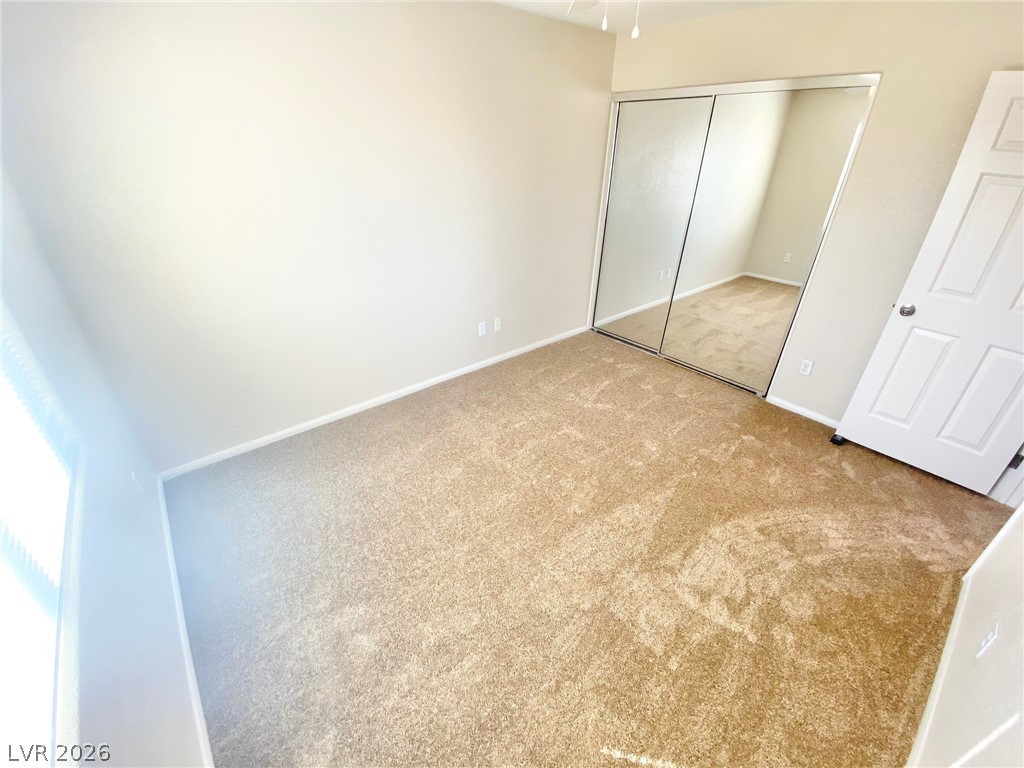8569 Rhamus Court Las Vegas, NV 89149 - Photo 18 of 35 A well-lit room offers ample storage with mirrored closet doors and soft carpet.