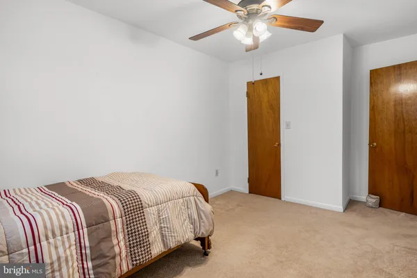 a bedroom with a bed and a ceiling fan