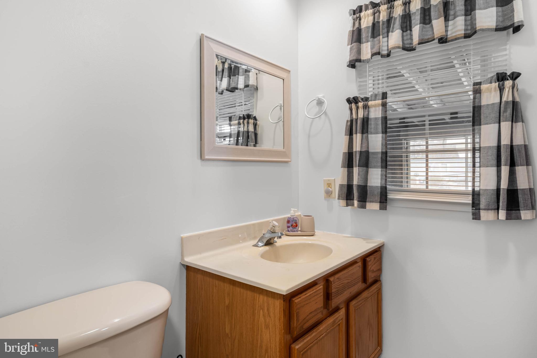 37526 Oak Street Ocean View, DE 19970 - Photo 28 of 36 a bathroom with a sink a toilet and a window