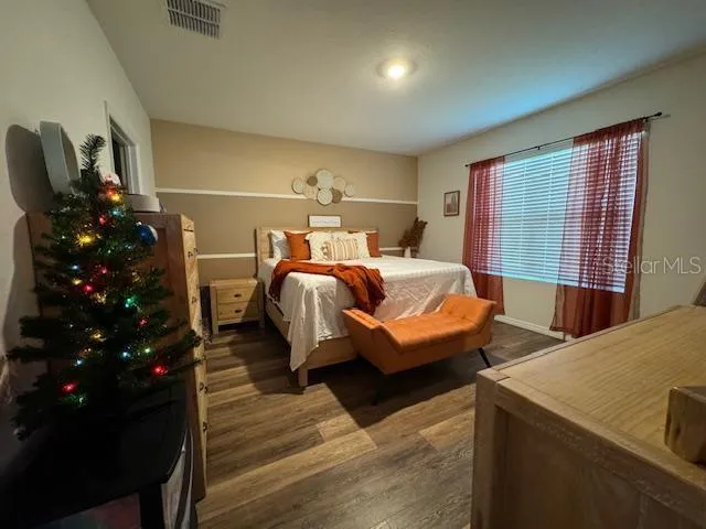 a bedroom with furniture and wooden floor
