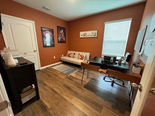 a living room with furniture and a wooden floor